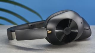 a pair of black bluetooth headphones made by OneOdio Focus A5 is photographed against a blue background