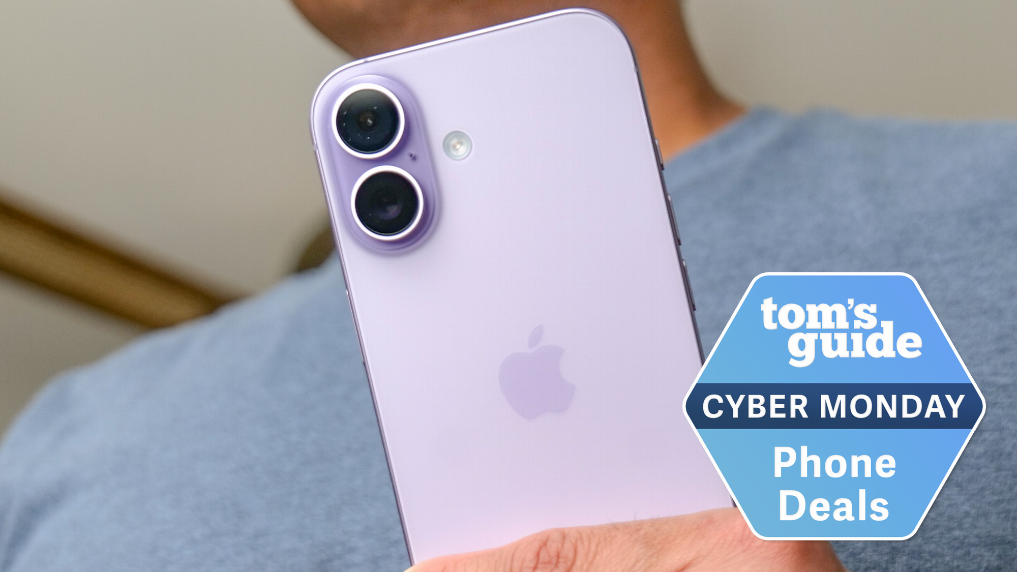 iPhone 17 held in the hand with Cyber Monday badge nearby.