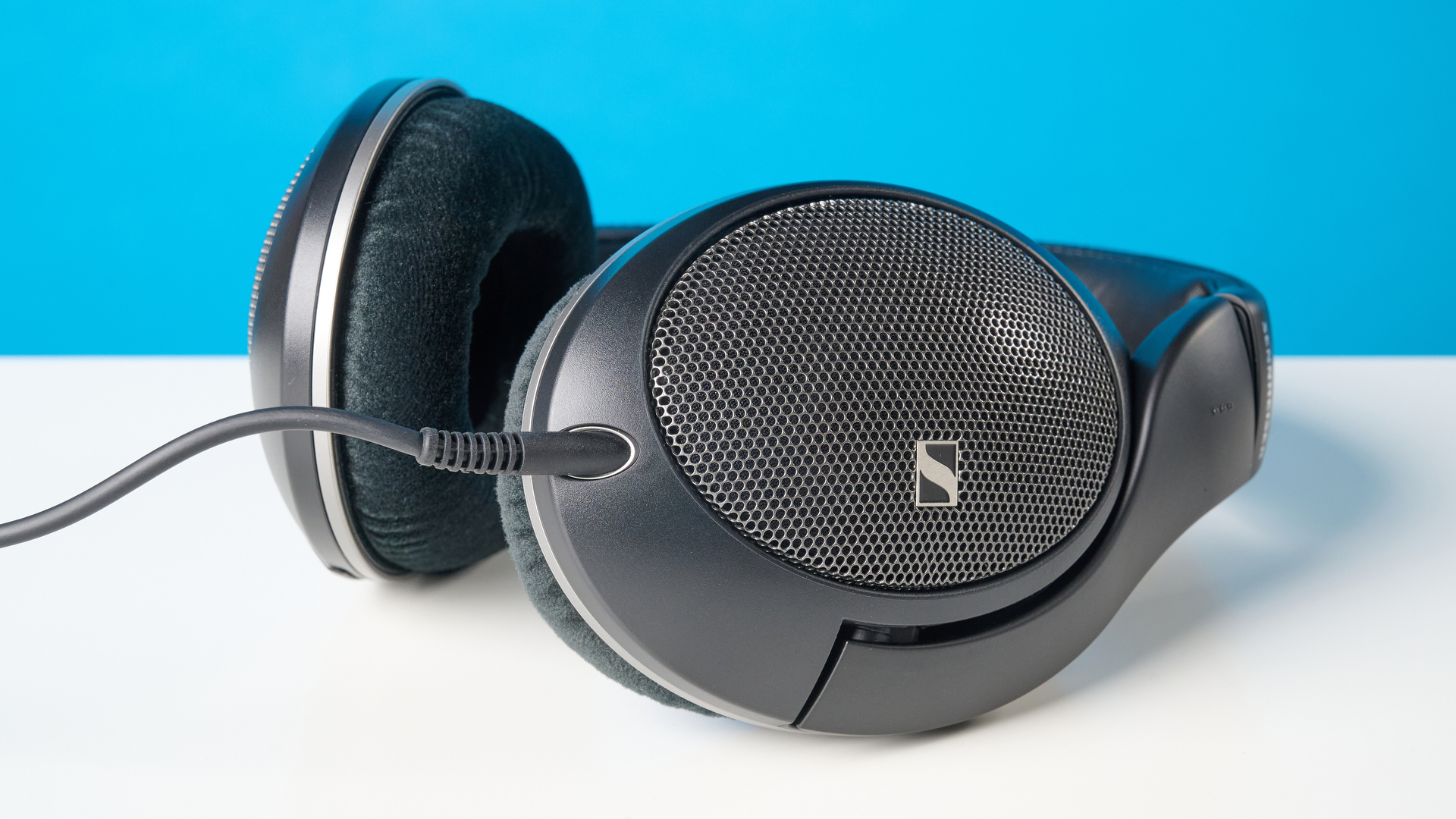 The Sennheiser HD 550 headphones on a stone surface with a blue background