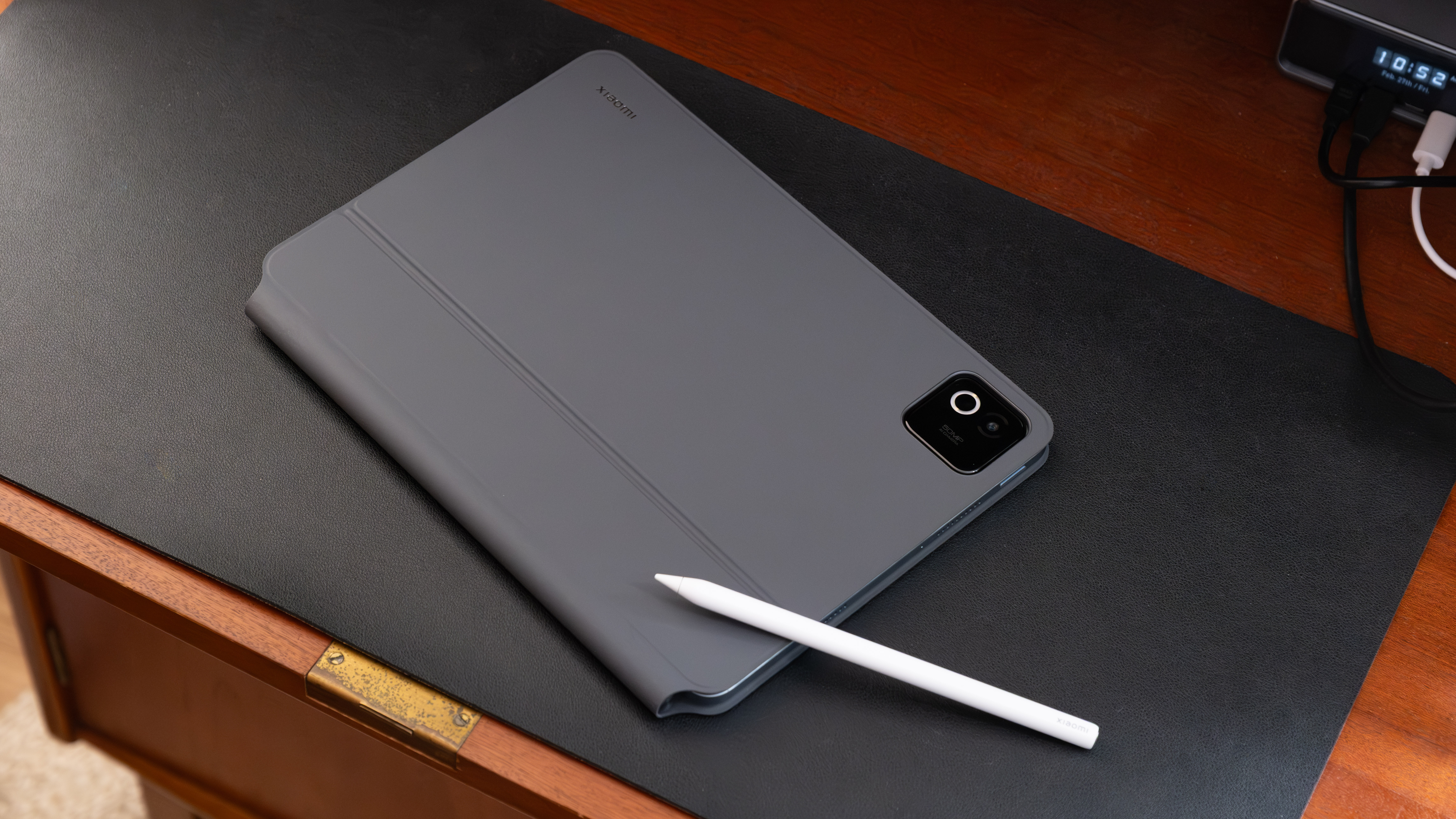 Xiaomi Pad 8 Pro closed in its folio-style case with stylus placed alongside on a desk.