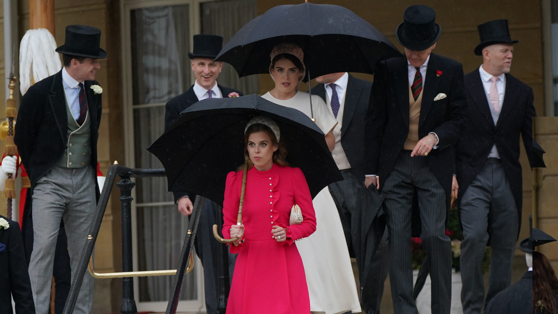 Princess Eugenie and Princess Beatrice walking down a staircase in dresses holding umbrellas