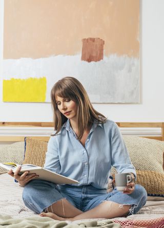 Woman reading a book with a cup of tea