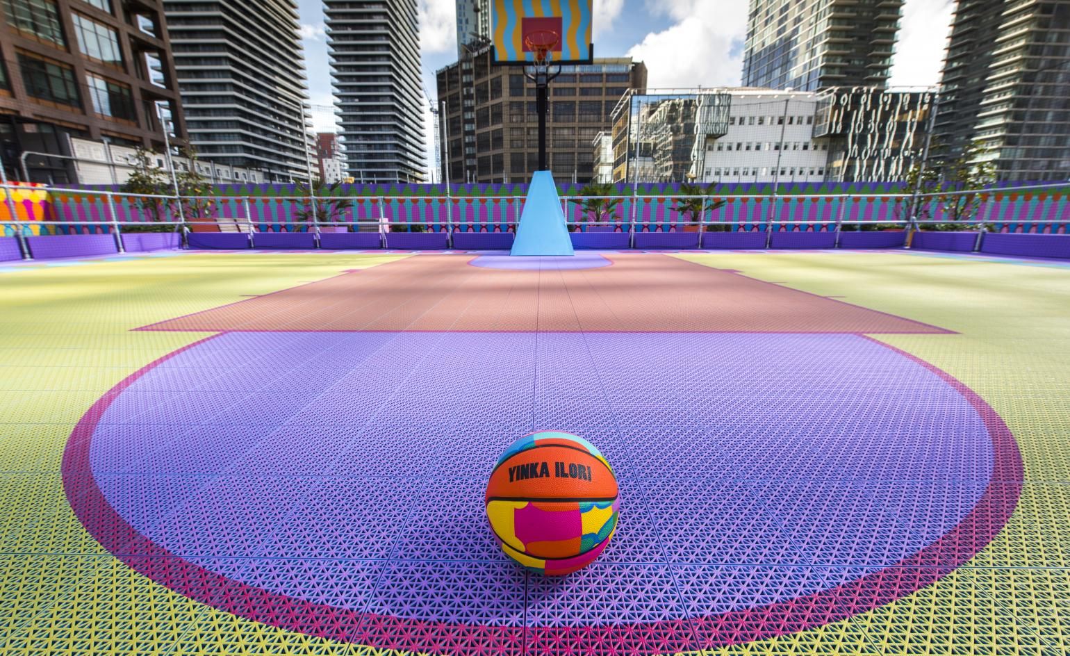 Yinka Ilori's colourful basketball caught in Canary Wharf Wallpaper