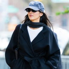 Kendall Jenner was spotted in NYC wearing an incredibly shoppable outfit: bootcut jeans, a black wrap coat, and pointy boots