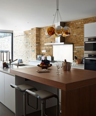 basement kitchen with worktops and brick wall