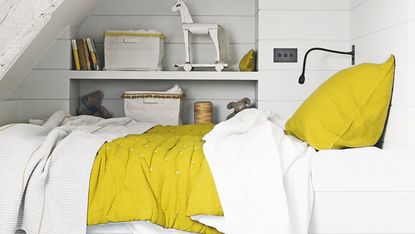Guest bedroom with white dresser and yellow lamp 
