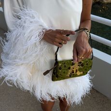 @juliesfi closeup photo in white feather-trimmed dress and valentino green jacquard printed shoulder bag