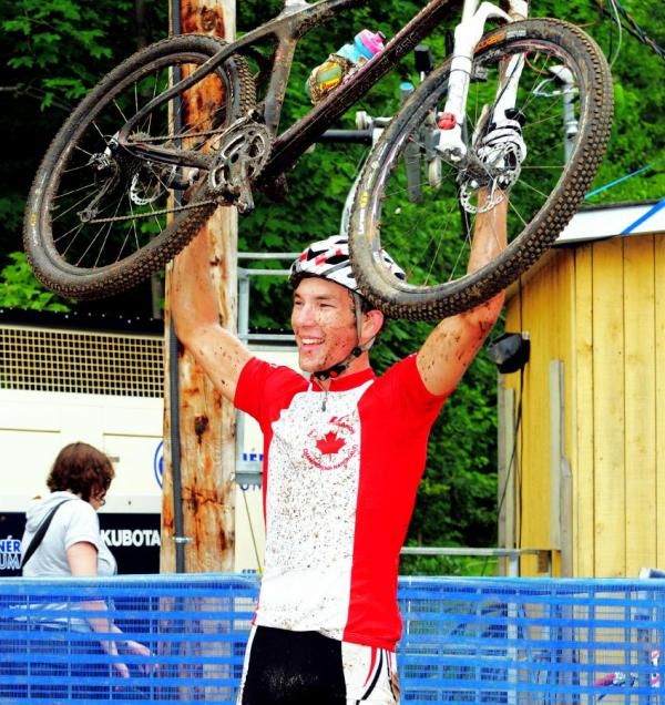 Evan Guthrie hoists his bike at the finish.