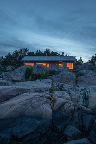 hero exterior at dusk of modest cabin in norway