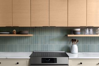 kitchen with wood cabinets and sage green backsplash by Erika Jayne Design