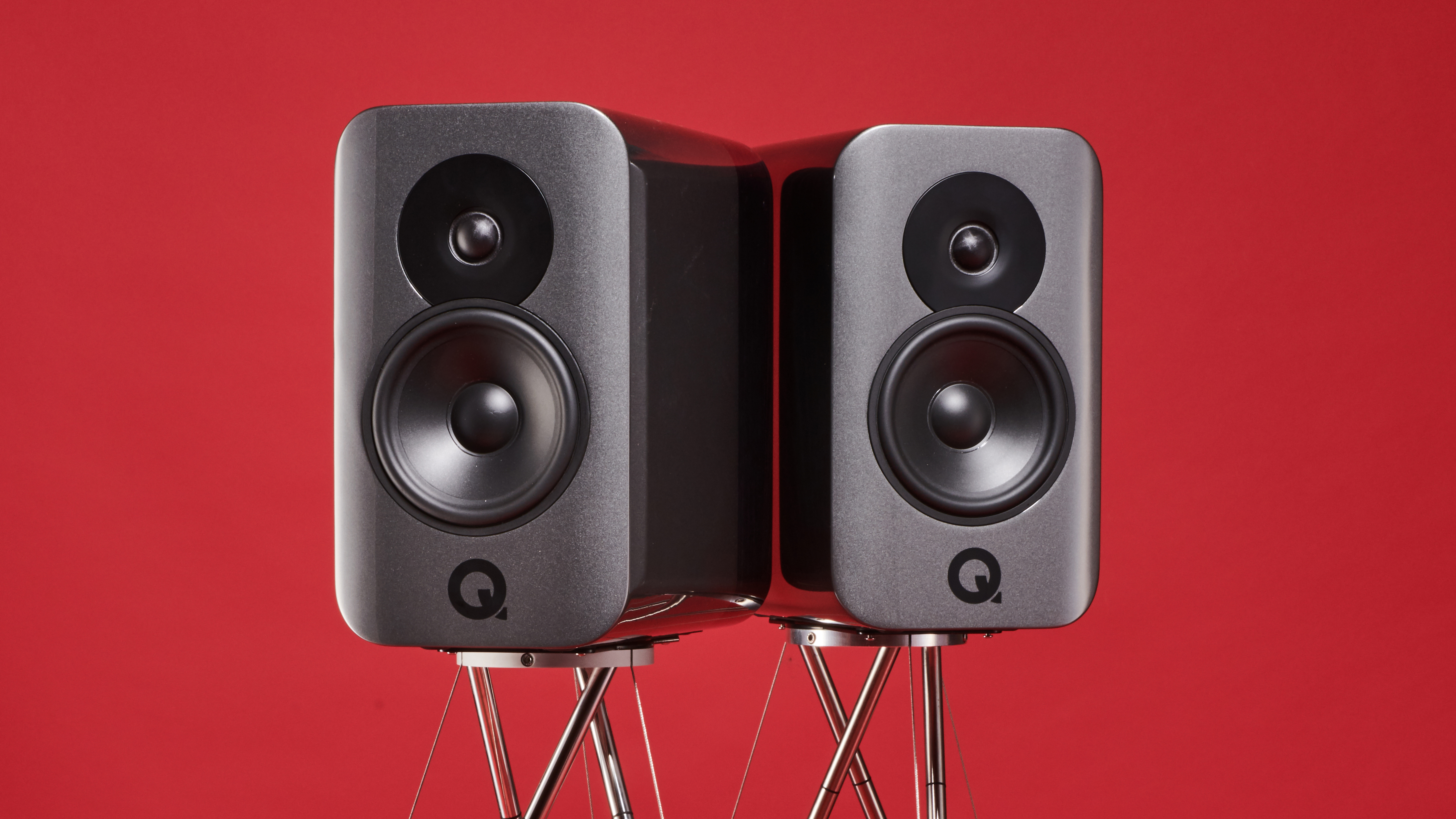 Q Acoustics speakers on a red background