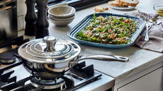 An image of a stainless steel saucier pan from Le Creuset on a stove