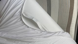 The Puffy Deluxe Mattress Topper folded over to show one of its its straps