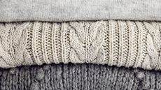 Close-up of three folded gray wool sweaters stacked