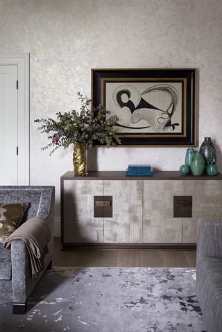 living room with gray sofas and artwork on wall above a console