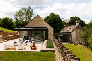 stone clad pitched roof extension to traditional cottage with outside patio