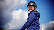 A smiling Lola Wade riding a horse