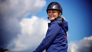 A smiling Lola Wade riding a horse