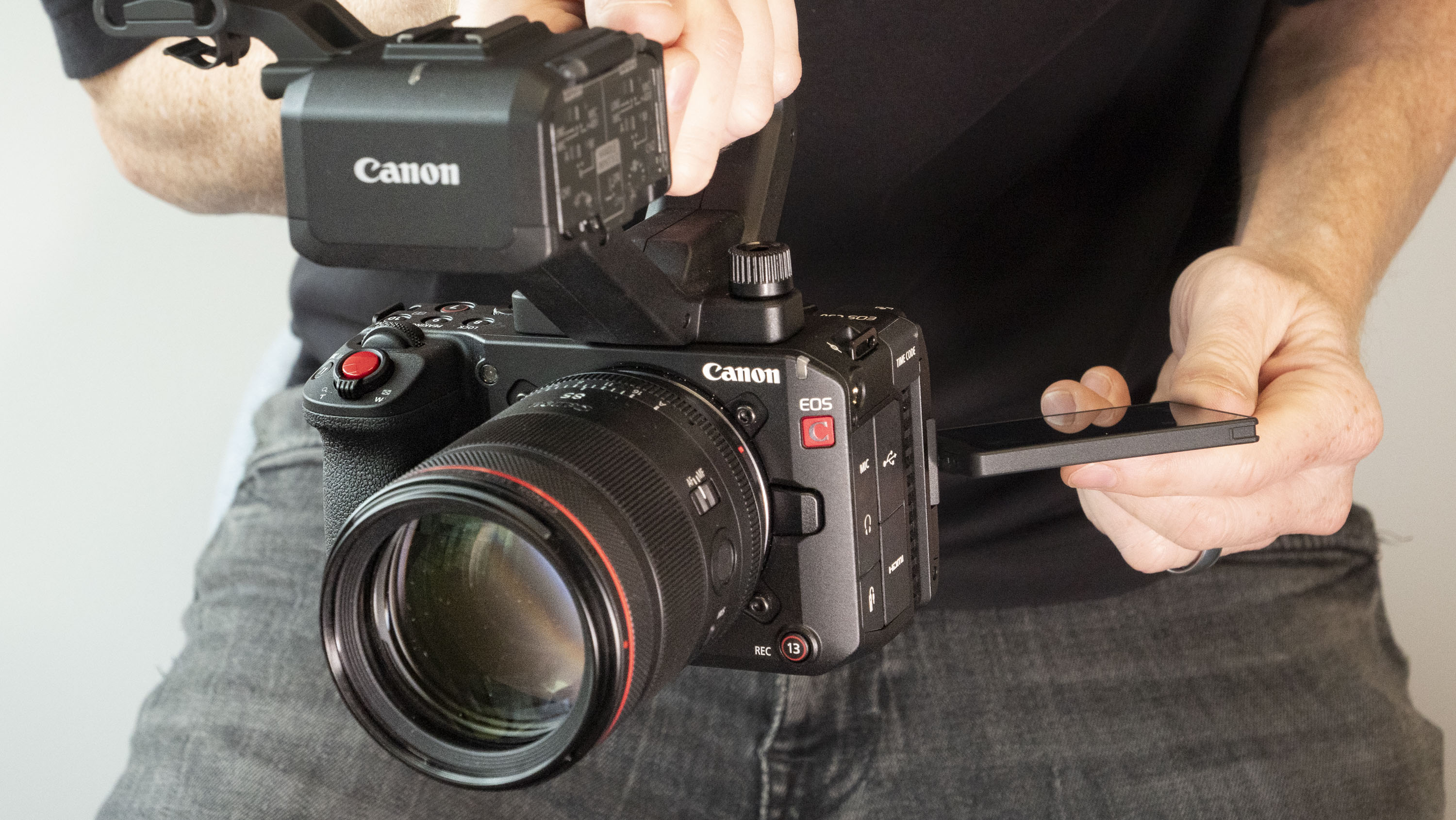 Canon EOS C50 with top handle, held by a filmmaker