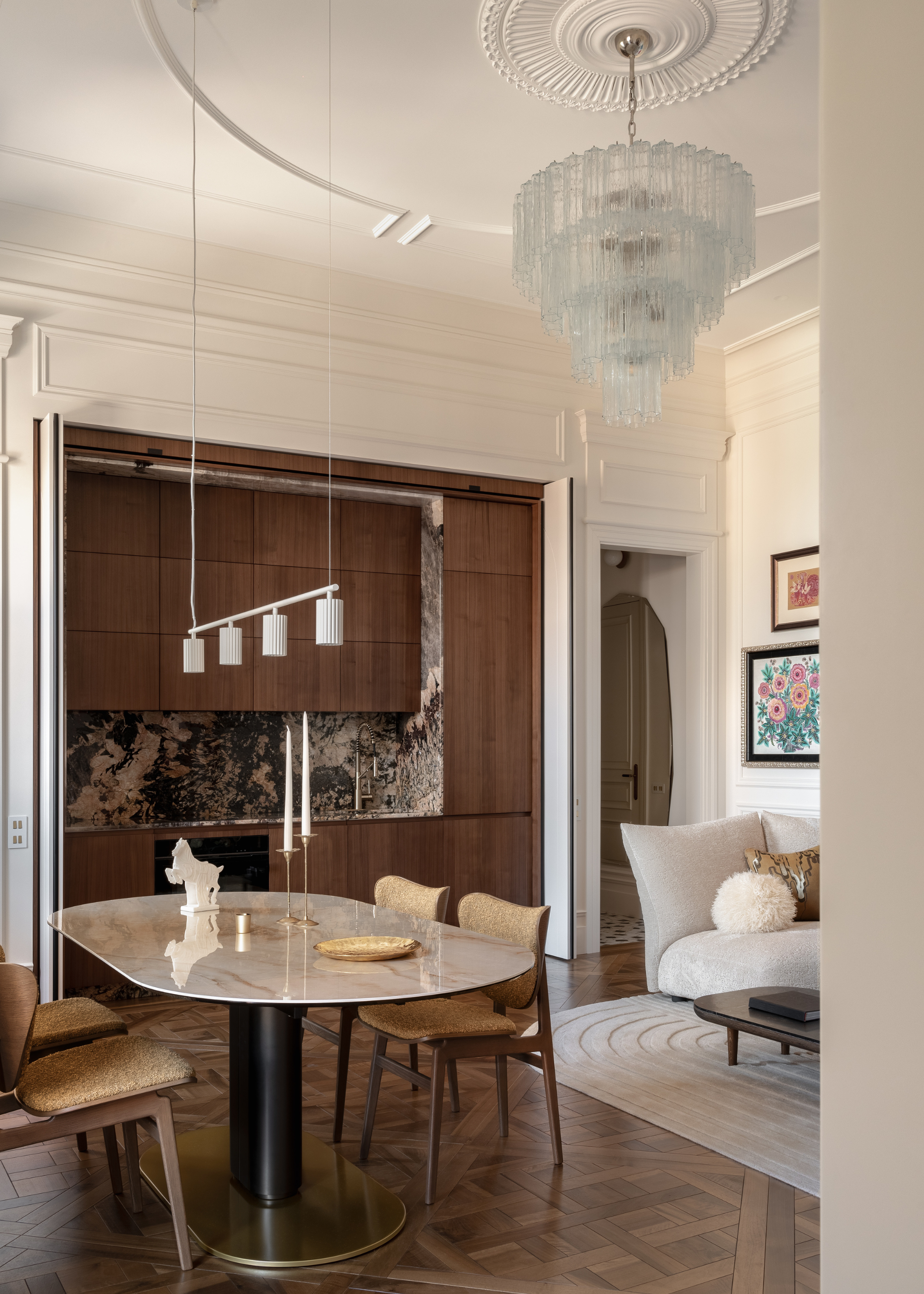 A mod small kitchen with a stone backsplash attached to an open dining and living room