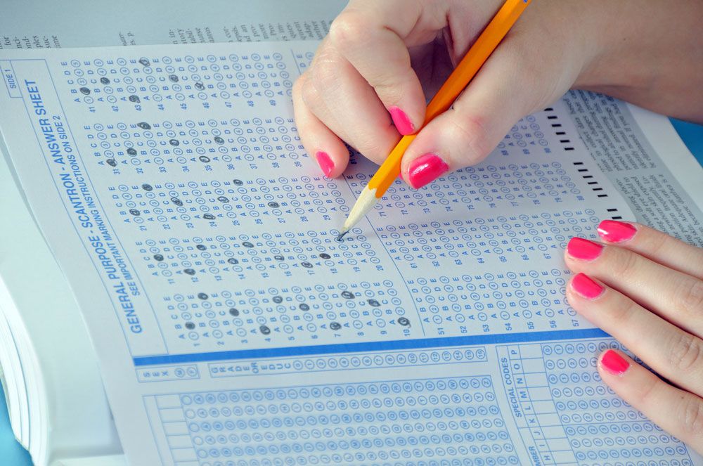 a student with neon pink nails taking a standardized test