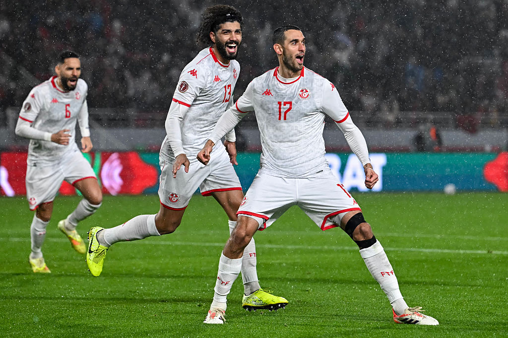 Tunisia's defender #06 Dylan Bronn, Tunisia's midfielder #13 Ferjani Sassi congratulate Tunisia's midfielder #17 Ellyes Skhiri after he scores a goal during the Africa Cup of Nations (CAN) Group C football match between Tunisia and Uganda at Rabat Olympic Stadium in Rabat on December 23, 2025. (Photo by Paul ELLIS / AFP)