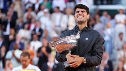 Carlos Alcaraz clutches the winner's trophy after his victory in the 2024 French Open