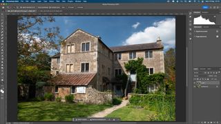 A Photoshop screenshot of a country home and duplicated background layer in the Layers panel