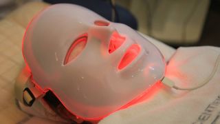 Someone using an LED face mask with red lights