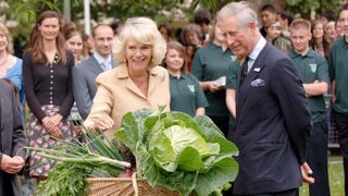 King Charles and Queen Camilla are presented with vegetables from the allotment as they visit the 'Dig for Victory' organic allotment in St James' Park on July 17, 2008