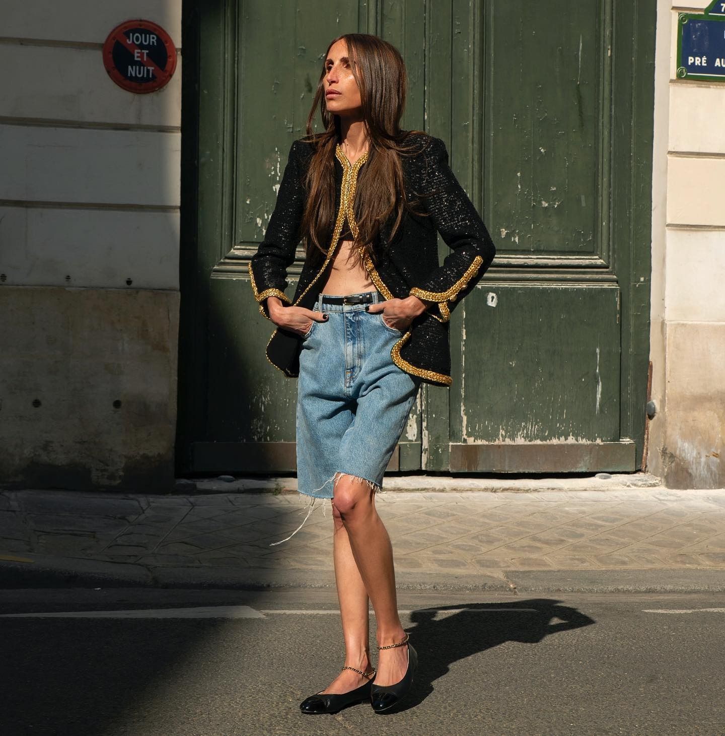 Woman wearing long denim bermuda short.
