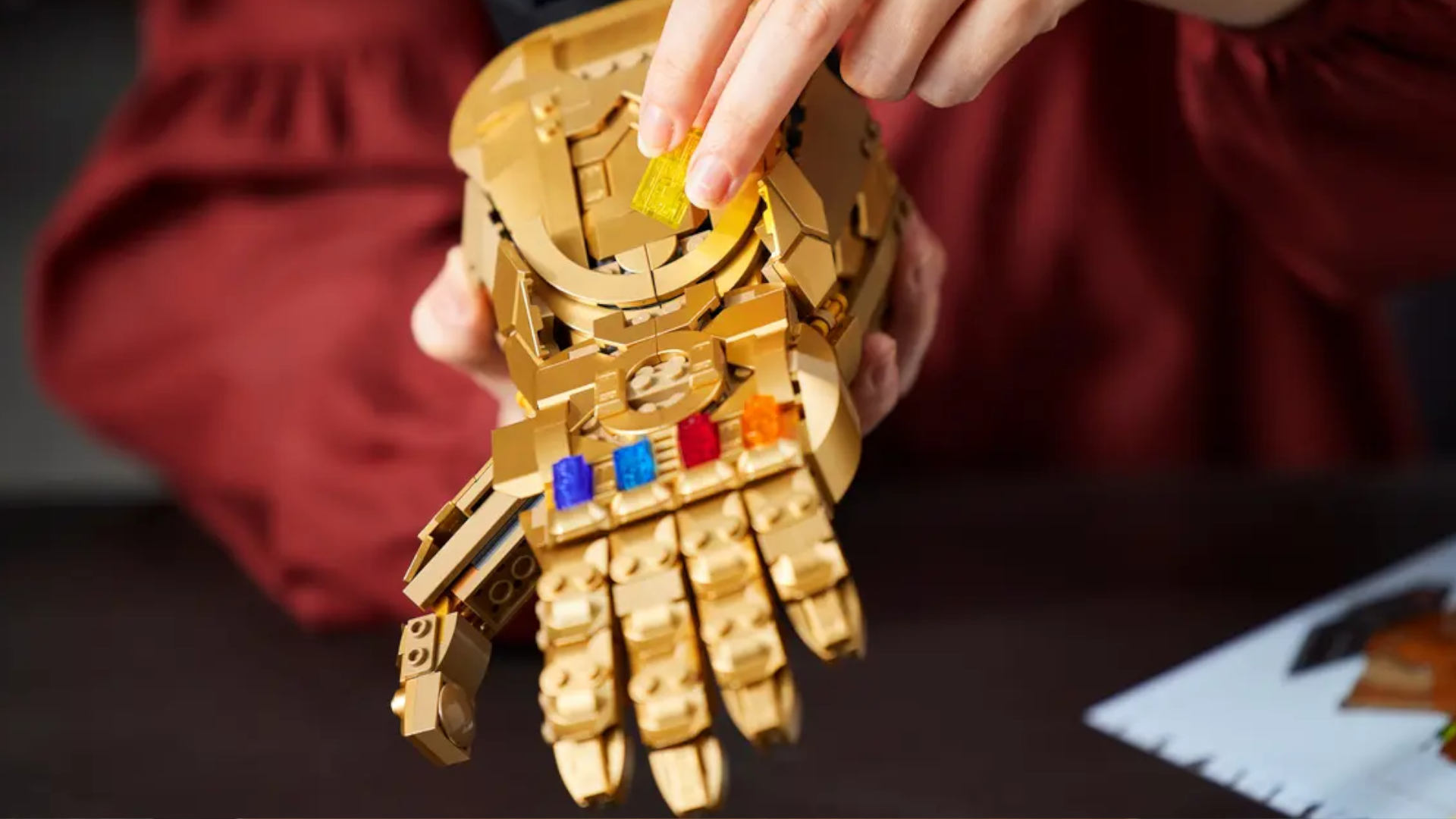 Lego Infinity Gauntlet with a hand placing the final stone