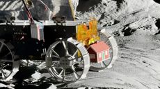 A photo of The Moonhouse model attached to the Tenacious rover in a simulated moon environment