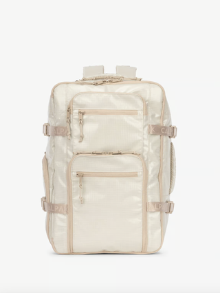 a white backpack in front of a plain backdrop