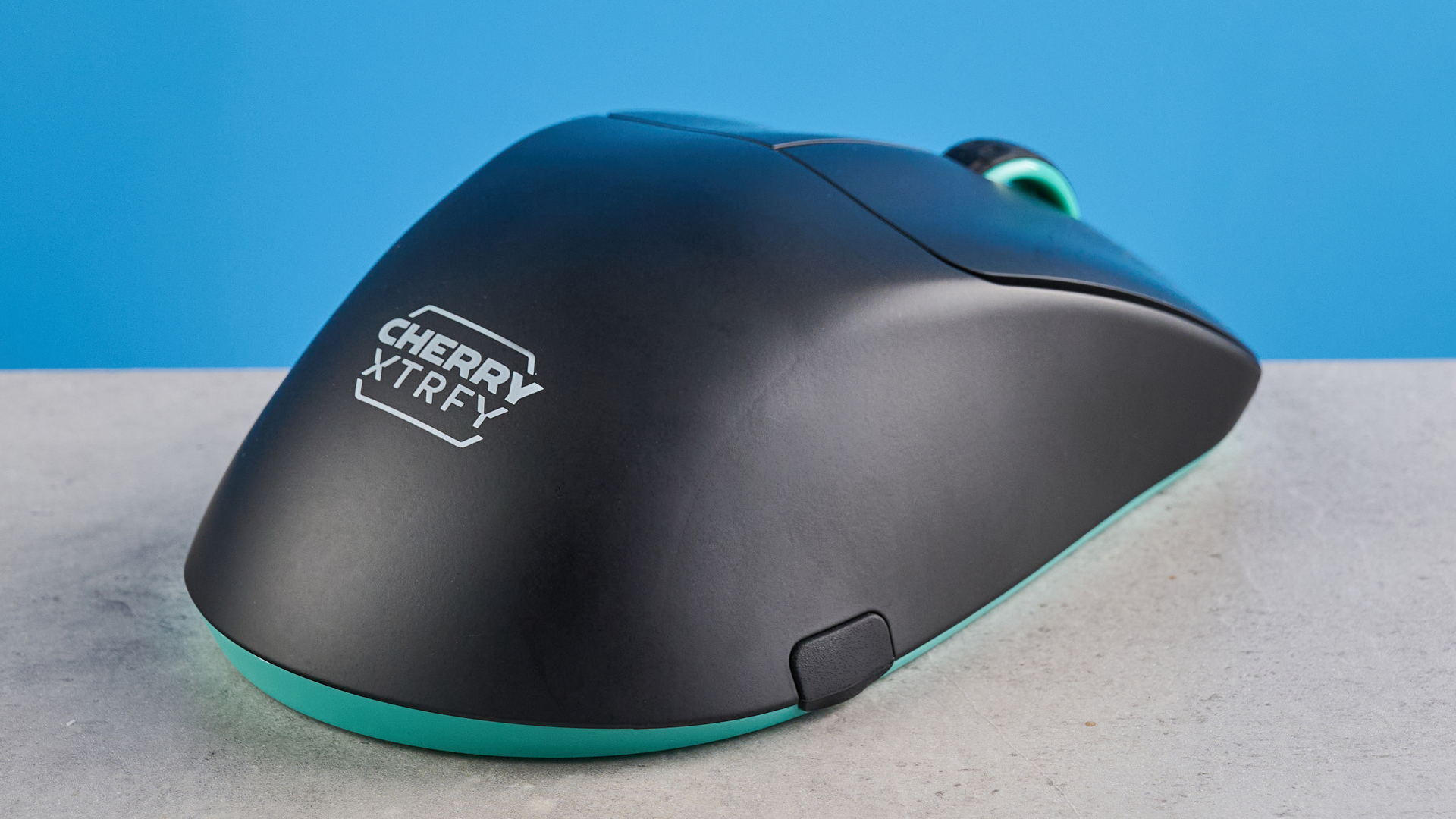 A black and teal Cherry XTRFY M64 Wireless gaming mouse