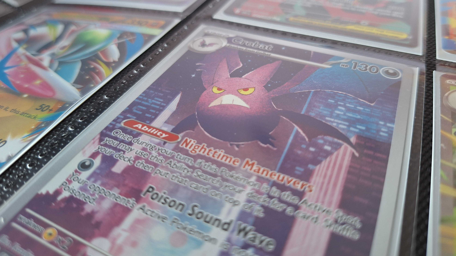 A Golbat card alongside others in a binder