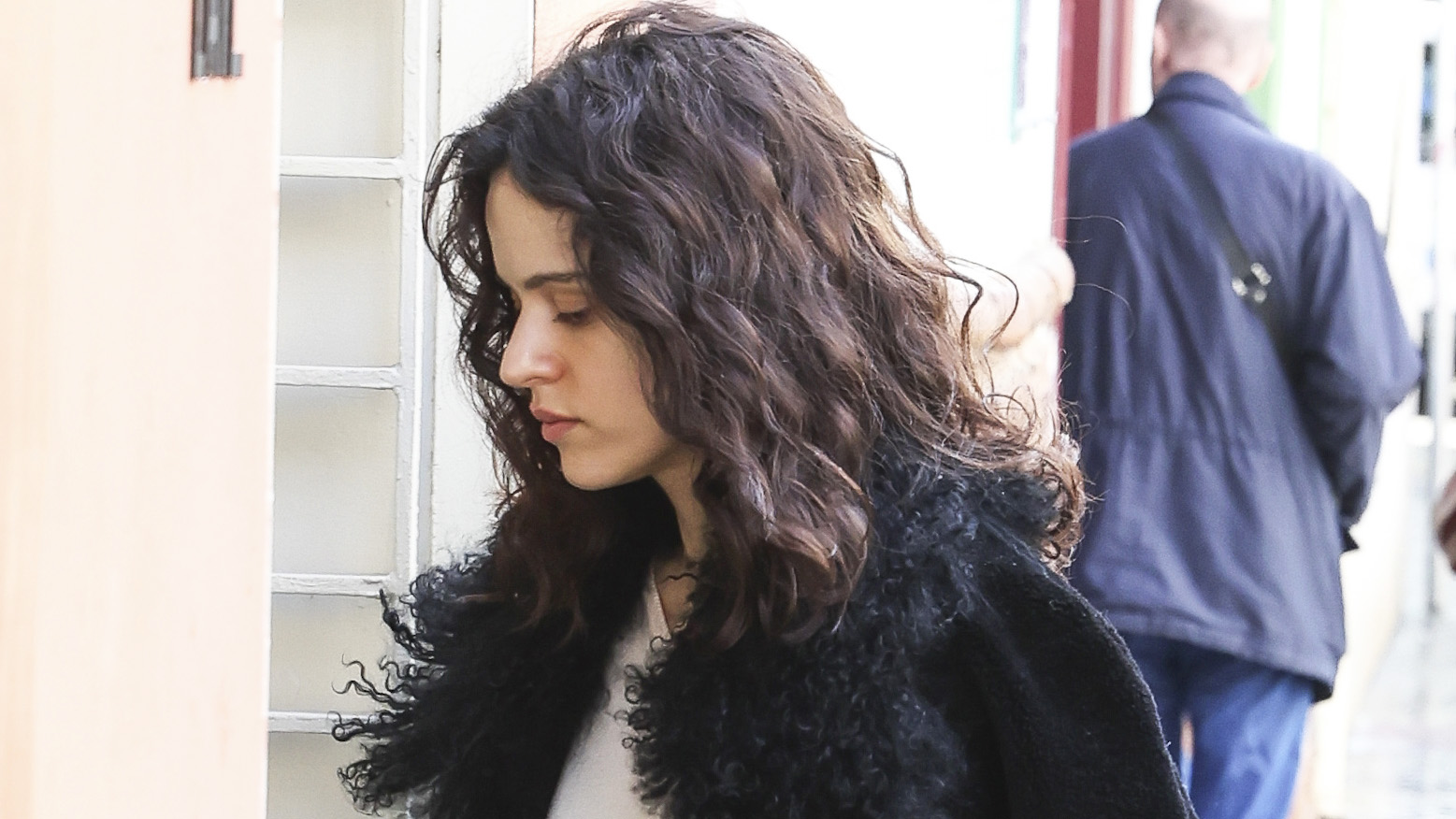 Rosalia wearing a fur-trimmed jacket with black capri pants and white ballet flats