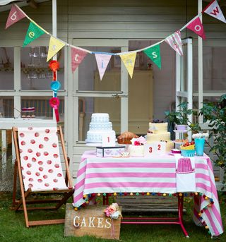 garden decorated for a birthday party with cakes and bunting