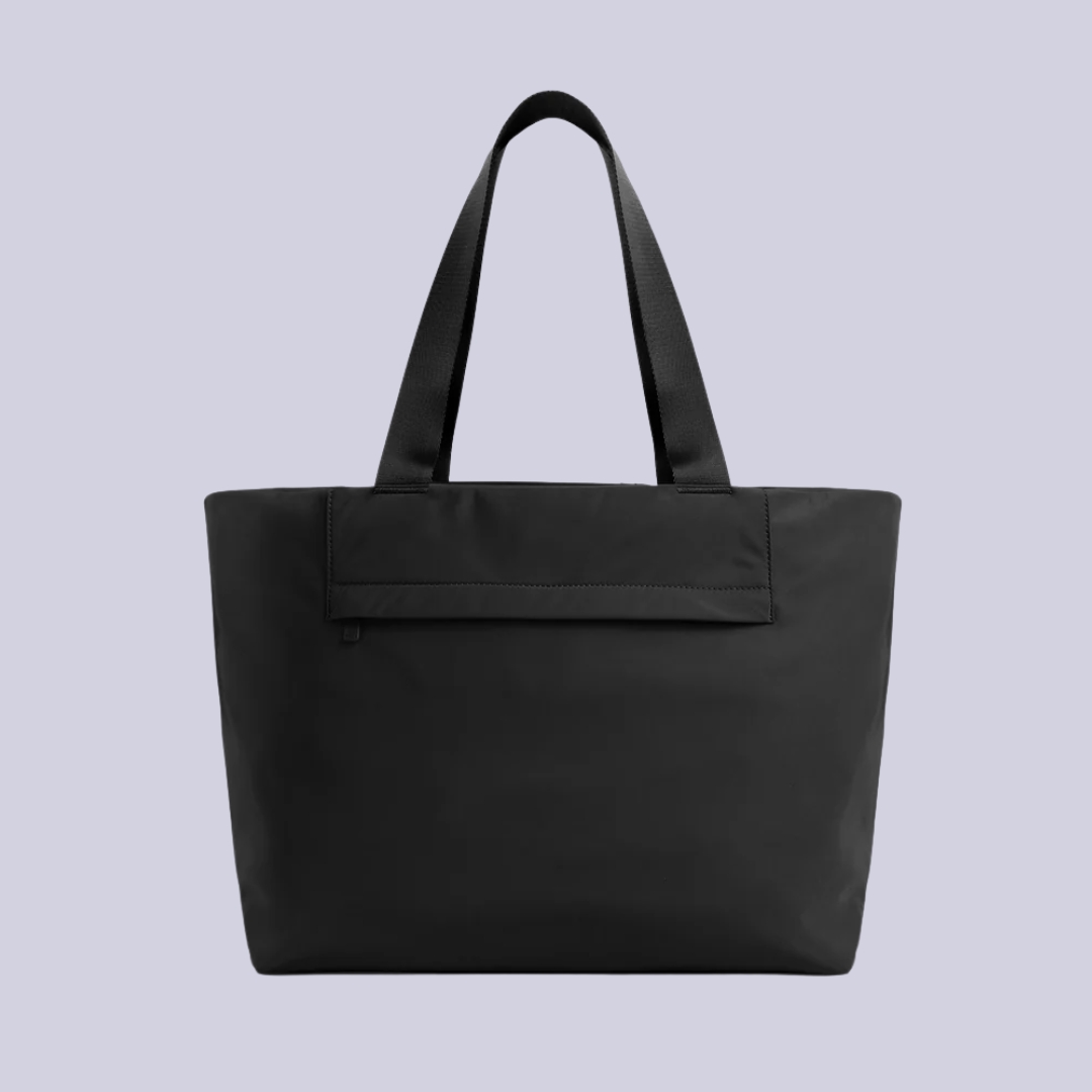 Featherlight Tote in black against a lilac background.