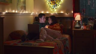 Ben and Devi sitting together on her college dorm bed in the final scene of Never Have I Ever.
