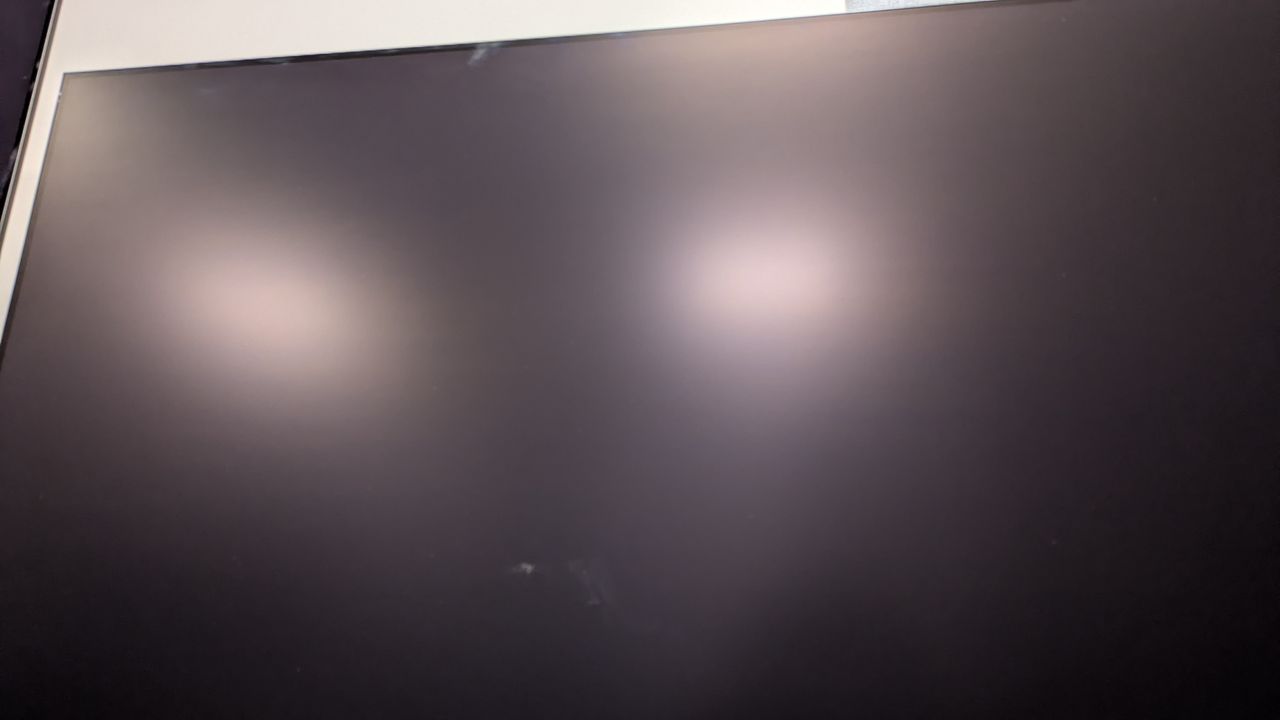 Samsung S95F with overhead lights reflected in screen