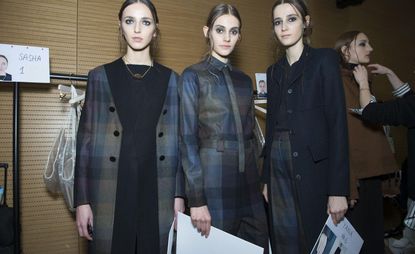 three female models wearing teal coloured coats