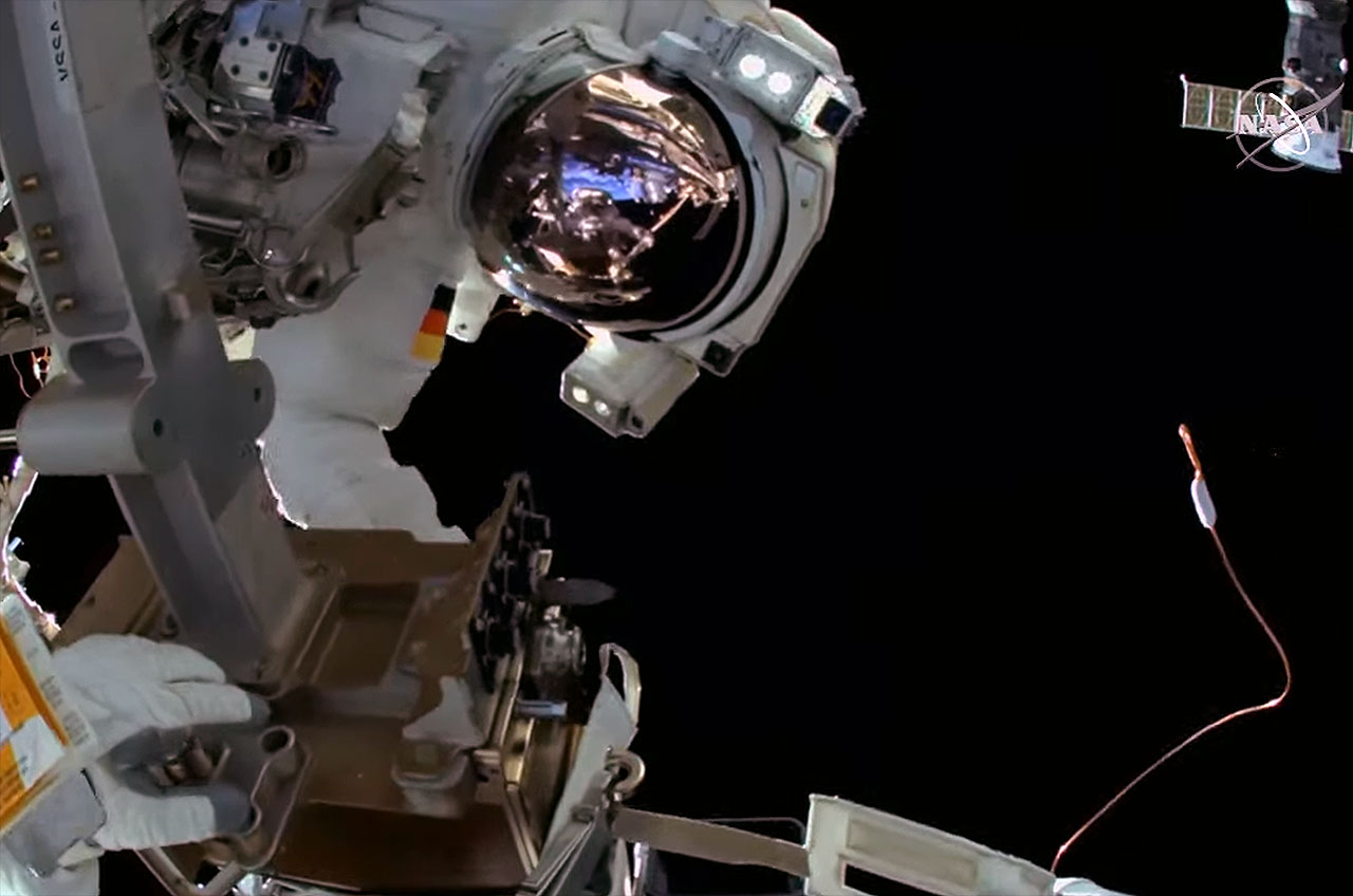 European Space Agency (ESA) astronaut Matthias Maurer, as seen from the helmet cam worn by NASA astronaut Raja Chari floats near a wire tie (at right) that is similar to the type used to tie down his own helmet-mounted camera at the start of their spacewalk outside of the International Space Station on Wednesday, March 23, 2022.