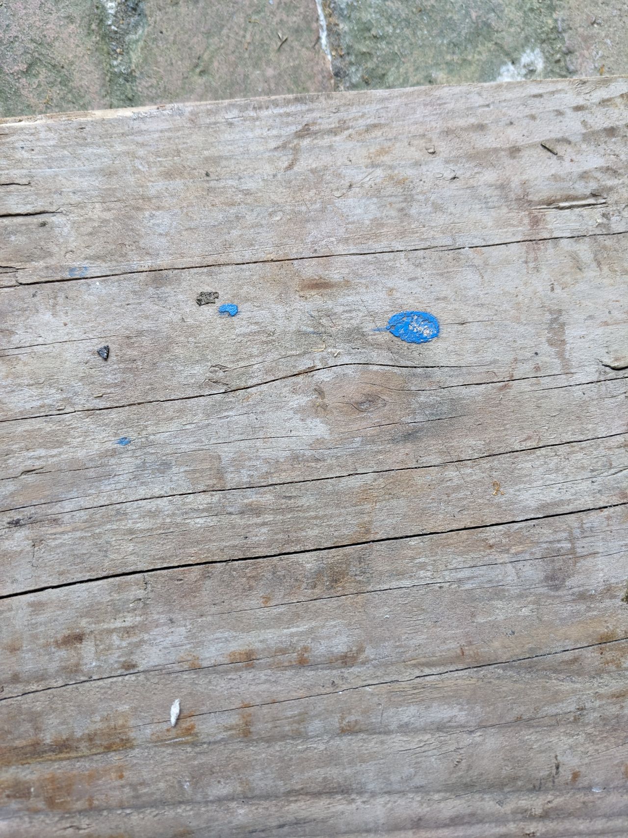 A close up of a paint splattered wooden board