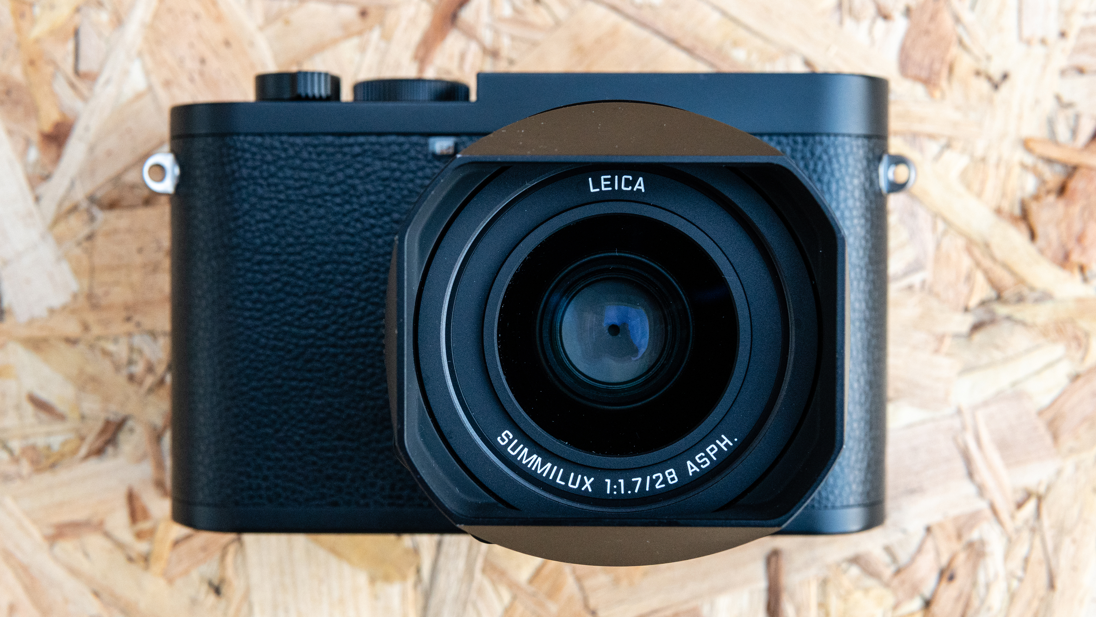 The Leica Q2 Monochrom resting on a woodchip panel