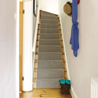 hallway with stairwell and carpet with white wall