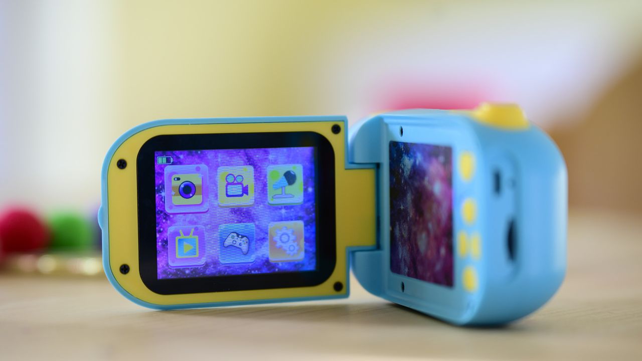 Cheap blue kids camera on a table with screen flipped out
