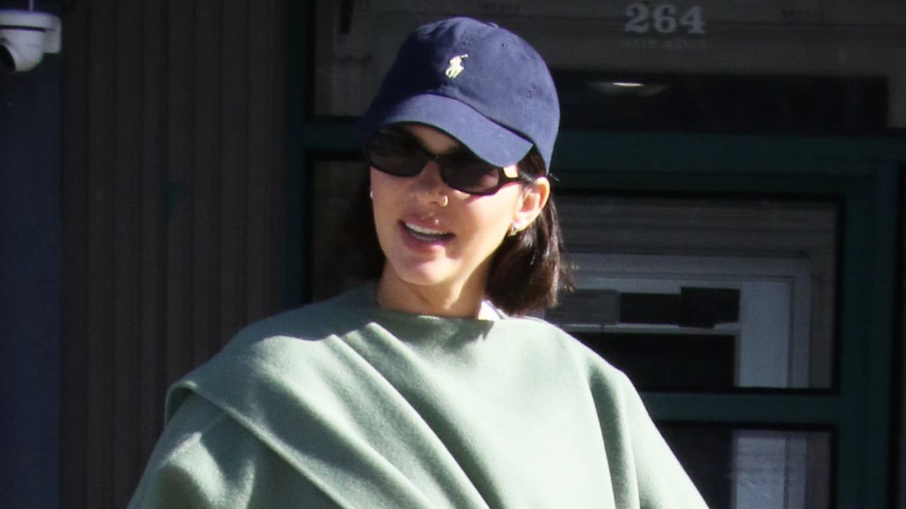 Kendall Jenner wearing a baseball cap and hoop earrings in street style