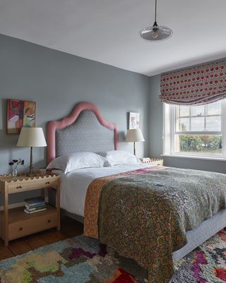 patterned bedroom with large bedhead and blue walls