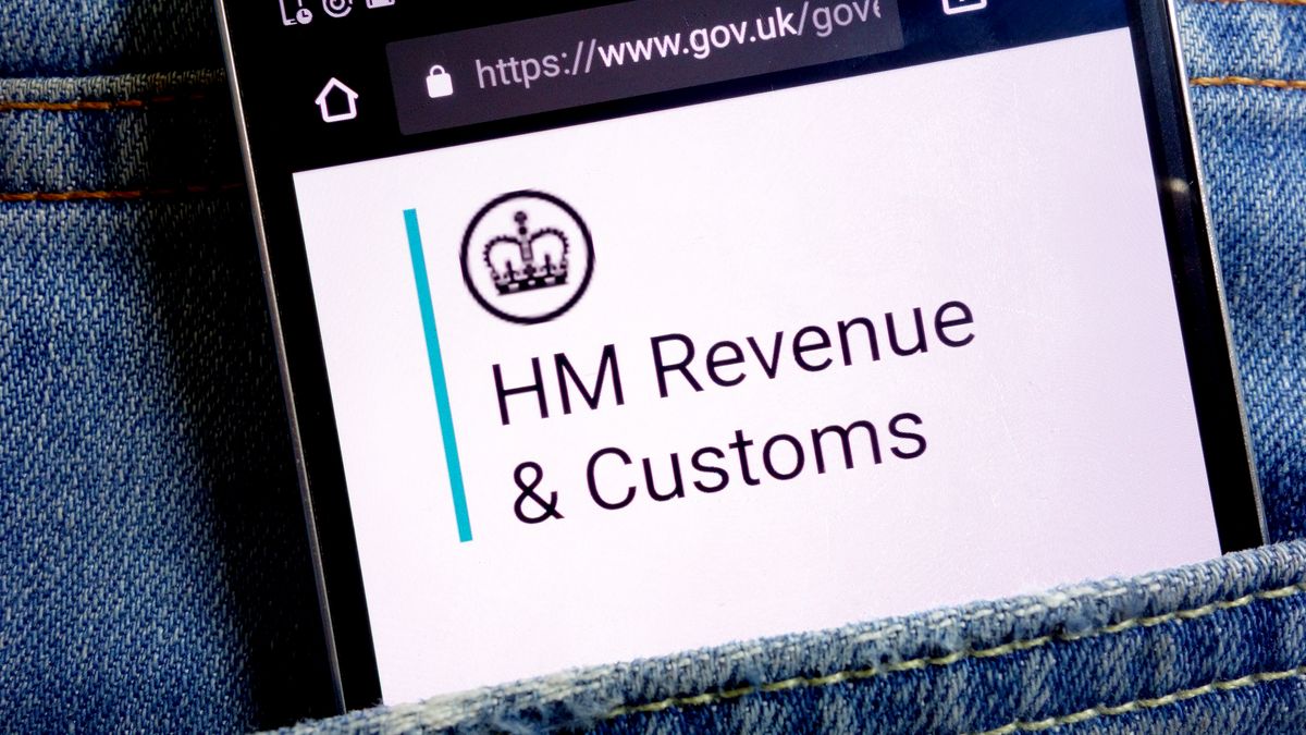 HMRC logo appearing on a smartphone which is nestled in the pocket of someone&amp;#039;s jeans